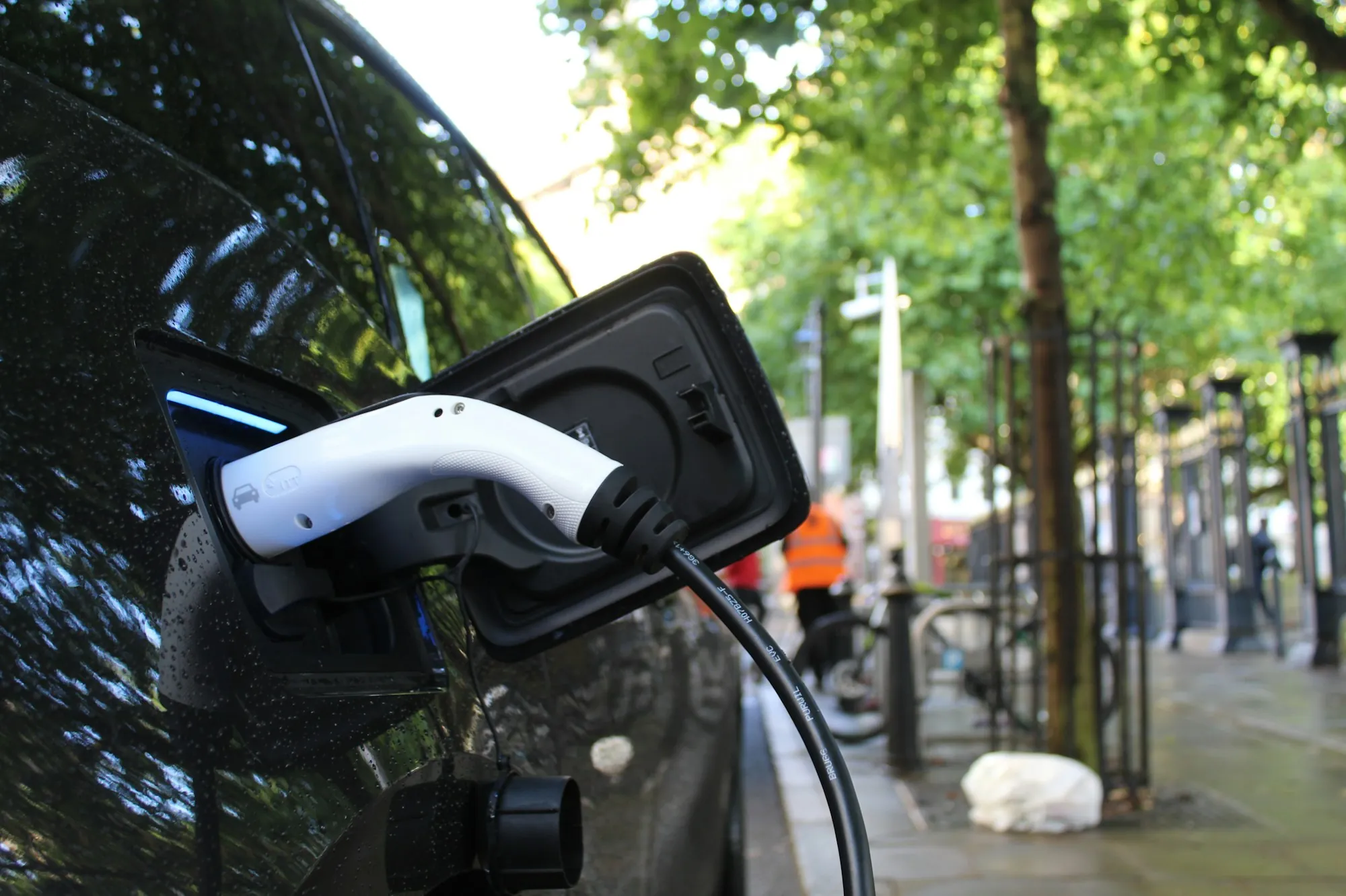 A charging cable connected to an electric car on a street