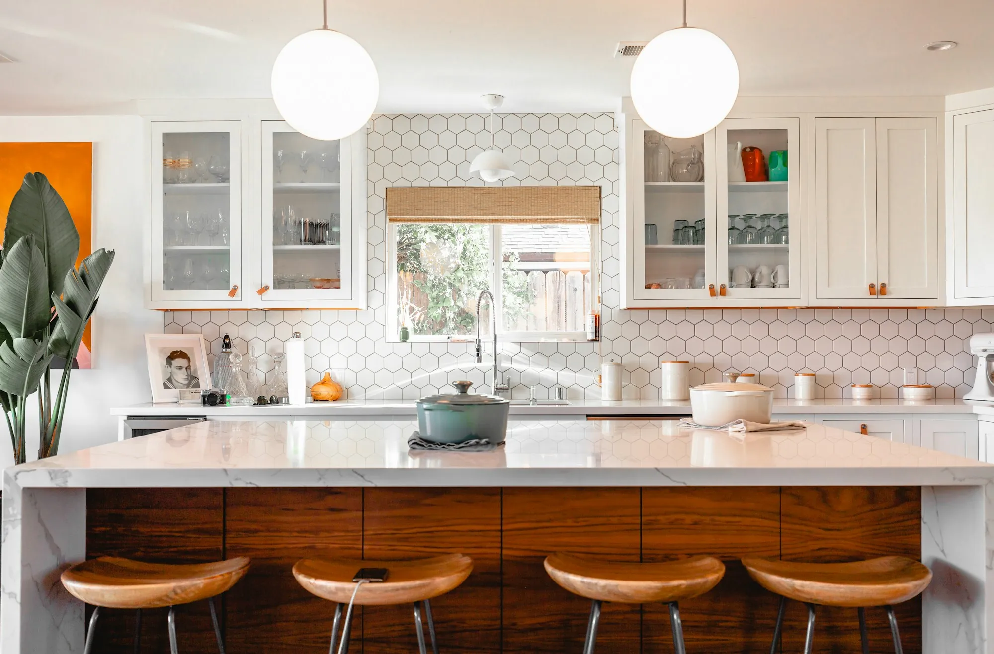 A bright residential kitchen lit by pendant lights